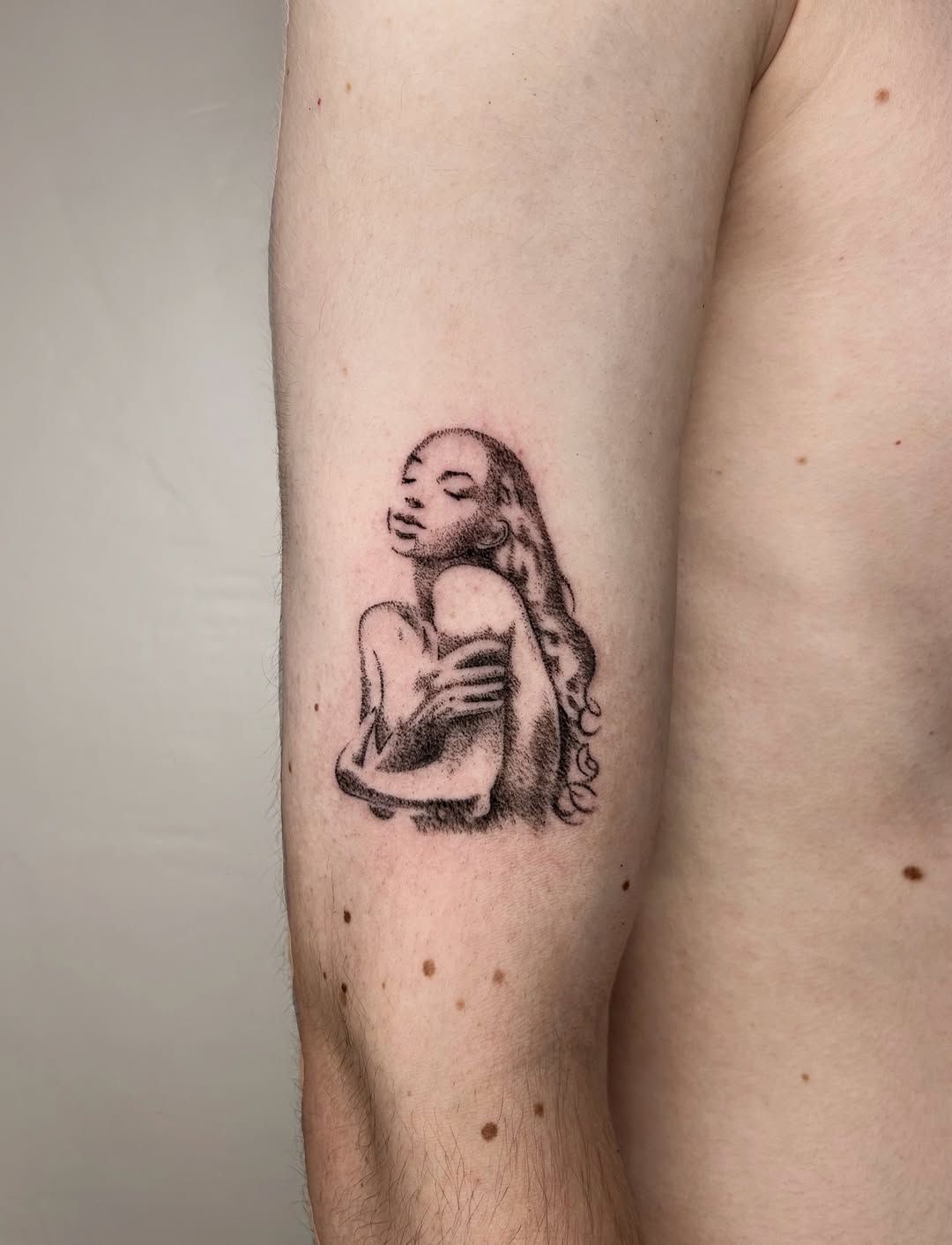Portrait féminin tatoué en pointillé à l’encre noire.